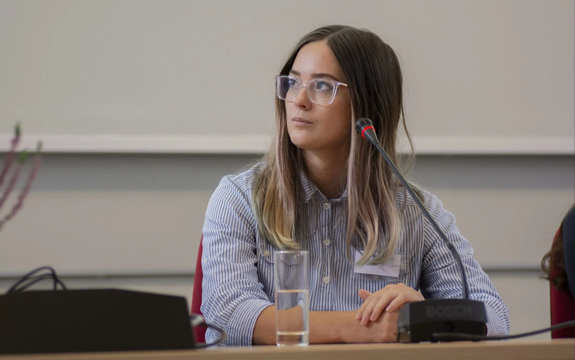 Veronika Gábor speaking at a panel discussion with a microphone